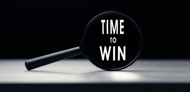 istock Magnifying glass with the text TIME TO WIN on table 1288396822