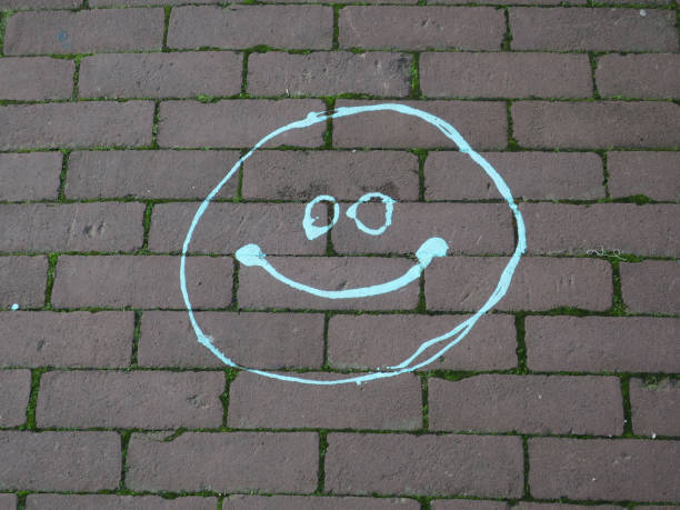 Smiley face drawn on blackboard with white chalk.