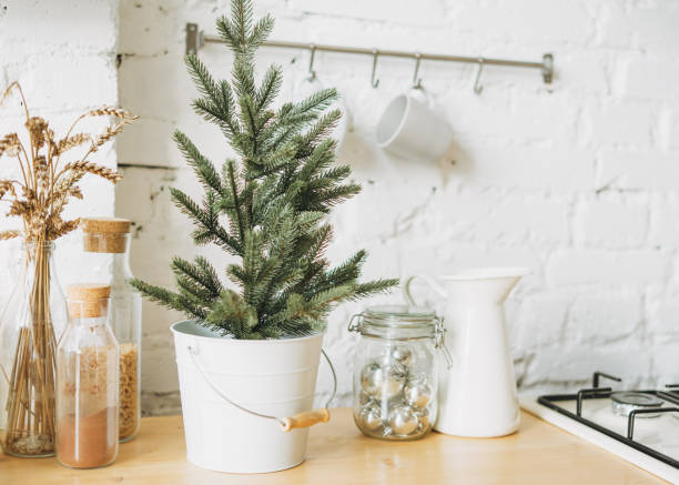 istock Christmas tree in white pot on the bright kitchen, cozy home 1288399772