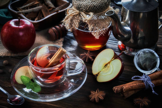 visão de close-up de alto ângulo de uma xícara de maçã e infusão de chá quente de canela em uma mesa em uma cozinha rústica - stevia tea herbal tea herb - fotografias e filmes do acervo