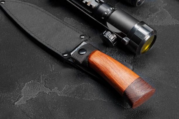 istock Hunting knife and optical sight for rifle on grey background 1288400661