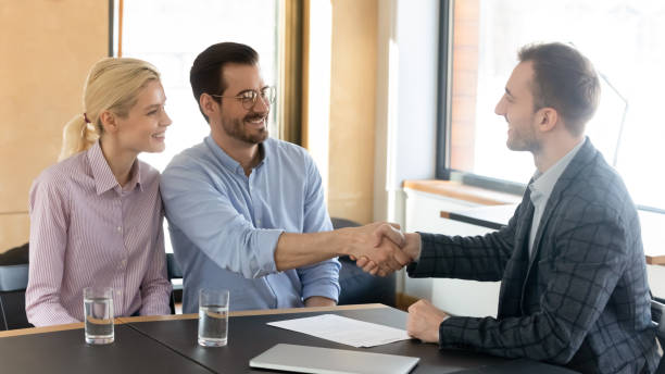 istock Smiling male financial advisor shaking hands with clients. 1288409451