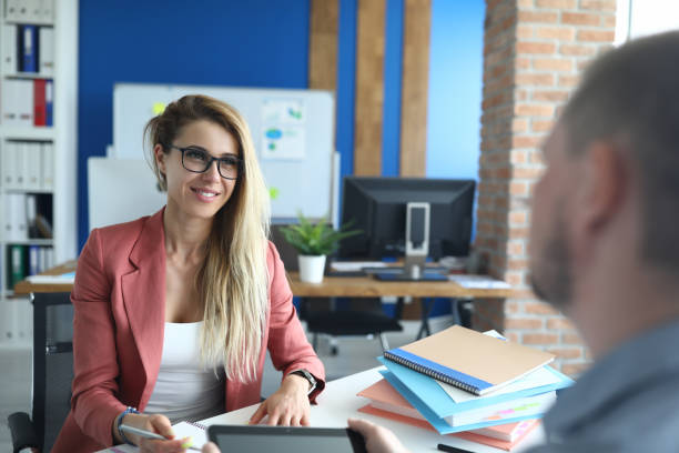 istock Young business woman in office is interviewing man 1288409899