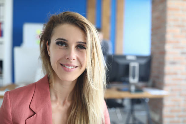 istock Smiling business woman standing in office 1288409900