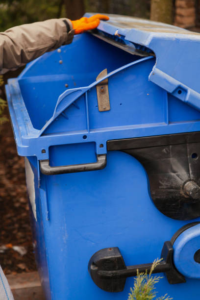 istock Hand opens lid of trash can 1288411555