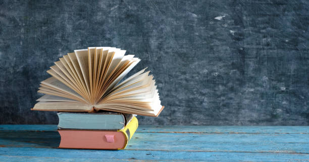 istock opened book on a stack of books, reading, education, education concept, panoramic,large free copy space 1288412702