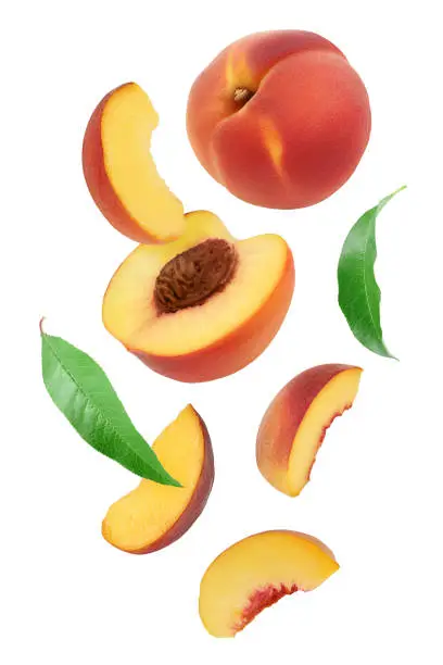 Photo of falling ripe peach slices isolated on white background