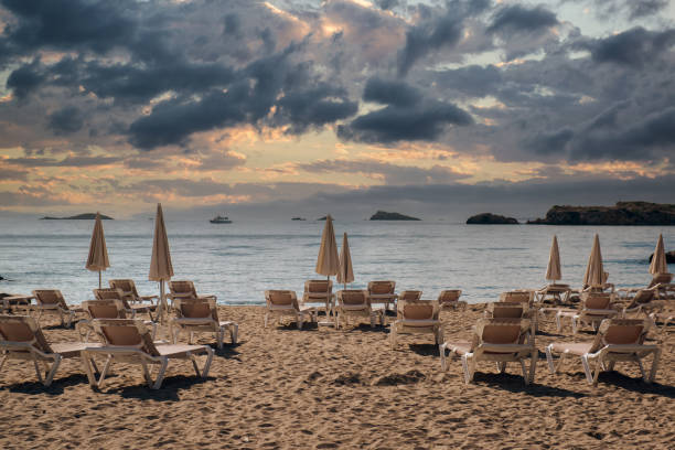 istock Parasols and deckchairs on empty beach of Ibiza at sunset. Spain 1288414098