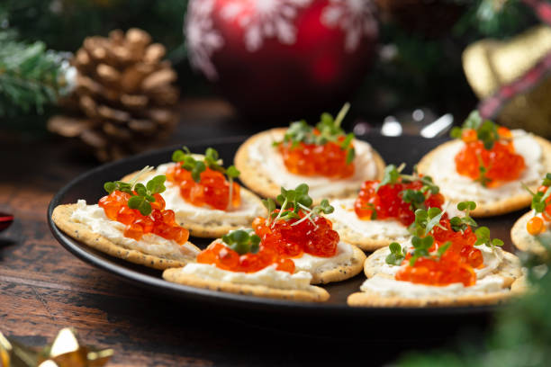 caviar de salmón y galletas saladas de queso suave con decoración, regalos, rama de árbol verde en mesa rústica de madera. - appetizer salmon smoked salmon cracker fotografías e imágenes de stock