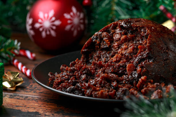 istock Christmas pudding with decoration, gifts, green tree branch on wooden rustic table 1288416246