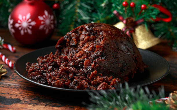 istock Christmas pudding with decoration, gifts, green tree branch on wooden rustic table 1288416319