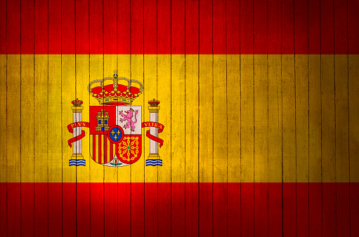 Spanish flag with the sign on a wooden background