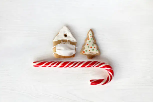 gingerbread house in a protective mask and a festive tree with a striped candy
