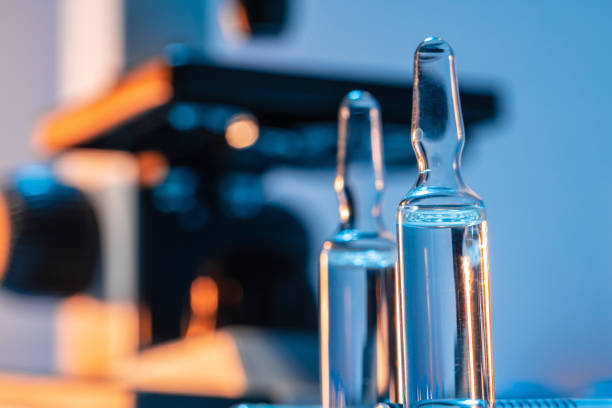 istock Medical vial with medication near microscope photo 1288420006