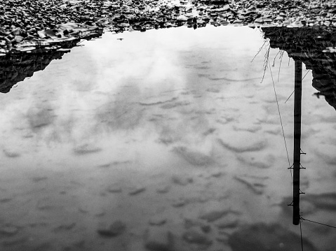 Farm track with pot holes in Alston, Cumbria. This is the reflection of a telegraph pole in the puddle.