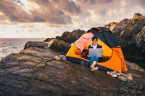 istock Working from distance concept. Female sitting in the tent and working on computer. 1288422526