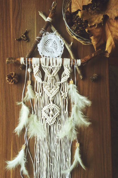 istock Handmade wall hanging white color with feathers. Home decor photo 1288428613