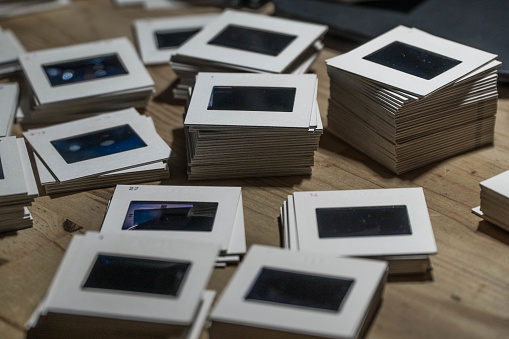Pile of piles of 35mm slides on a wooden table