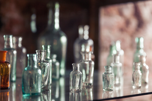 Vintage colored empty glass bottles and vases. Still life of retro style containers.  Beautiful horizontal arrangement. Ne and old recyclable garbage. Oriental, Turkish, Modern Pots and Flower Vases of Various Sizes.