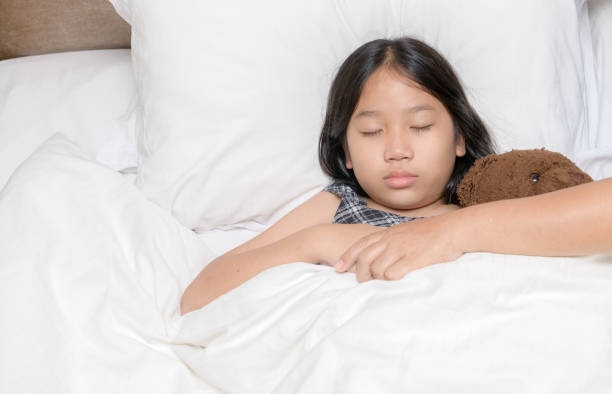 istock mother holding her daughter hand while she was sick in bed at home lovingly and caring. 1288431855