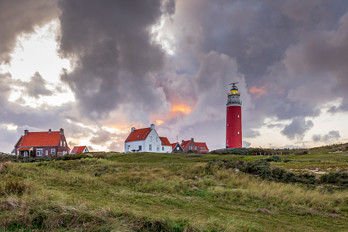 Landscape with scenic view of Lighthouse during sunset with rainy clouds at Waddenisland Texel, North Holland, Netherlands