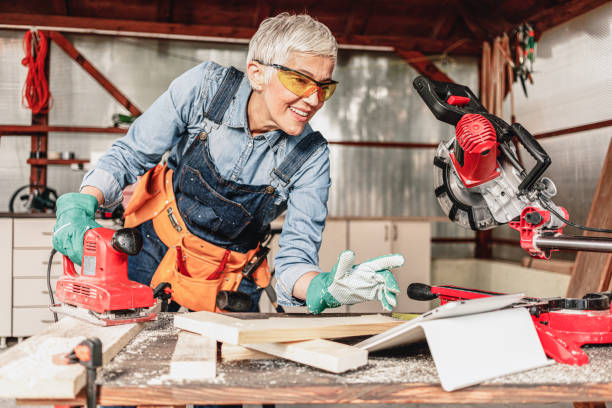 istock Mature female carpenter grinding plank and using digital tablet. 1288433362