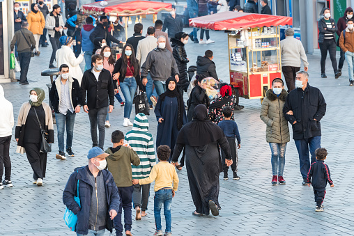 Unidentified Turkish people wearing protective face masks walking closely at the streets without social distance coronavirus COVID-19 epidemic.Istanbul,Turkey.16 November 2020