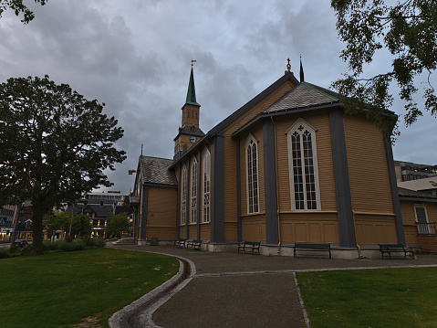 Tromsø, Norway - 08-23-2020: Rear view of historic wooden church Domkirke (Evangelical Lutheran) located in the old center of Tromsø on cloudy day in evening.