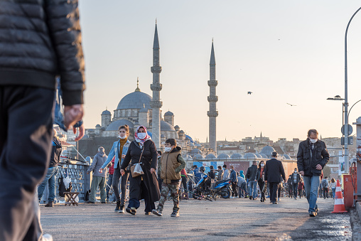 Unidentified Turkish people wearing protective face masks walking at Galata bridge during coronavirus COVID-19 epidemic.Istanbul,Turkey.16 November 2020