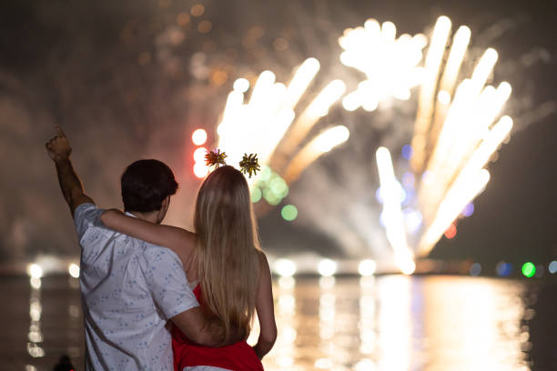 istock Young couple enjoy firework during celebration festival on the beach. 1288437032