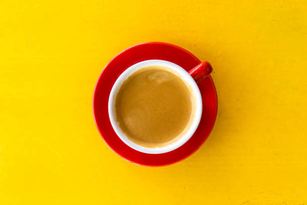 a photo of a red coffee mug on a yellow table - coffee top view imagens e fotografias de stock