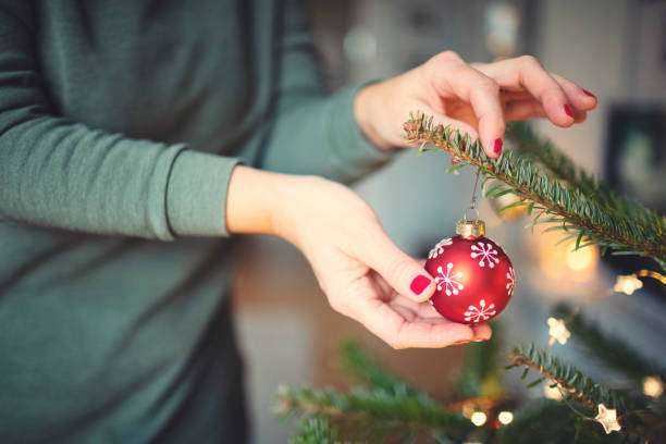 istock Attractive woman decorates the Christmas tree 1288437905