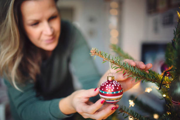 istock Attractive woman decorates the Christmas tree 1288438797