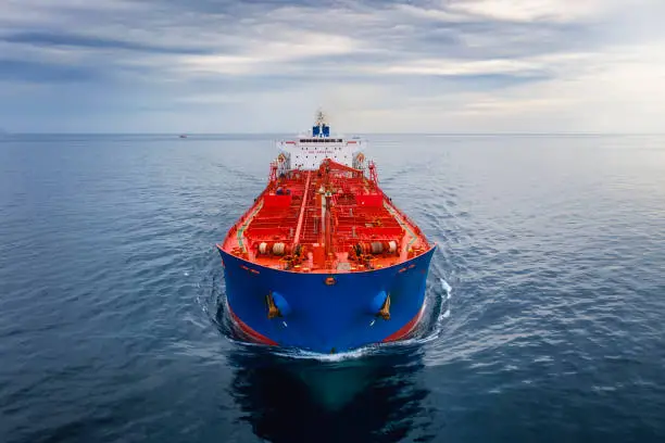 Aerial front view of a cargo tanker traveling over calm sea