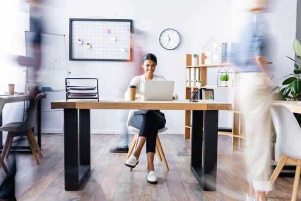 istock happy african american manager working at laptop in open space office, motion blur 1288442024