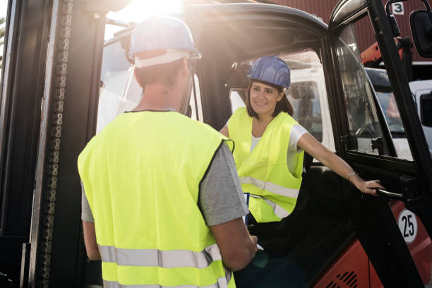 istock A woman drives a forklift in a construction work environment. She have a conversation with a man. The image shows women equally in male tasks. 1288442138