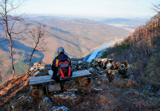 joven con una mochila de la espalda sentado en un banco y mirando el cañón del río drina, serbia - bench mountain park sitting fotografías e imágenes de stock