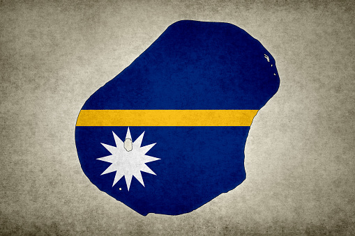 Grunge map of Nauru with its flag printed within its border on an old paper.