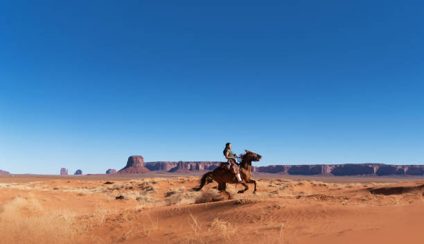 navajo młoda kobieta jedzie szybko na koniach w monument valley arizona - usa - brown boy zdjęcia i obrazy z banku zdjęć