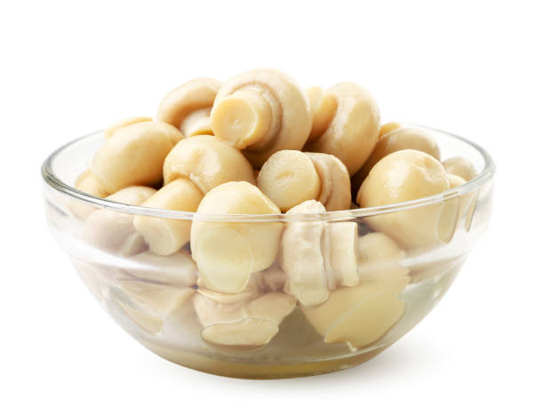 istock Canned champignons in a glass plate on a white background. Isolated 1288457337