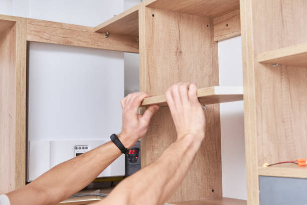 istock Male carpenter install shelf in kitchen cabinet 1288458231