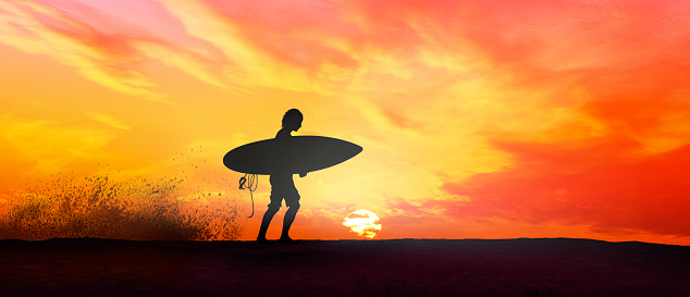 Surfer at beautiful sunset walking with surfboard
