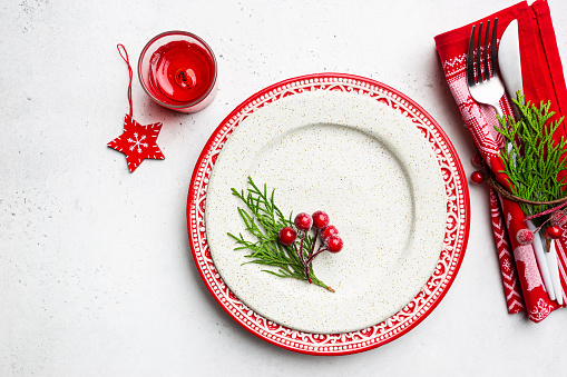 Christmas table setting with christmas decorations on white background. Top view, copyspace.