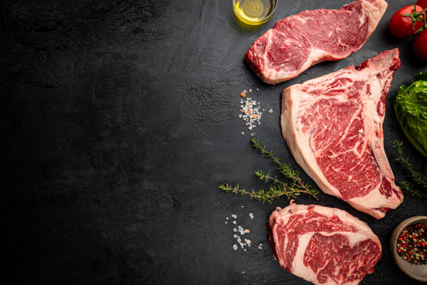Variety of Raw Meat Steaks Variety of Fresh Raw Black Angus Prime Meat Steaks T-bone, New York, Ribeye and seasoning on black background, top view chopping food photos stock pictures, royalty-free photos & images