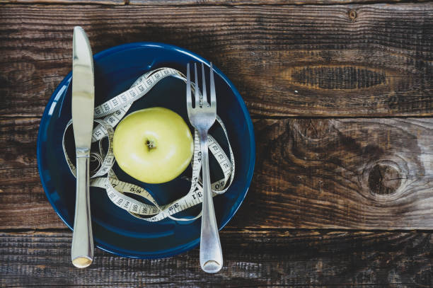 istock apple on plate with measuring tape 1288461911