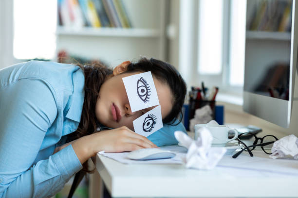 tired businesswoman napping at her desk - asleep on the job imagens e fotografias de stock