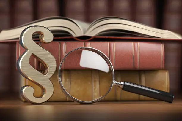 Paragraph sign with loupe and books. Searching, justice and law concept. 3d illustration