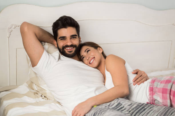 istock Young couple in pajamas relaxing on the bed 1288463673