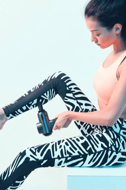 istock Percussion massager, athletic young brunette female massaging leg aching muscles, post-workout recovery routines 1288470412