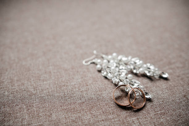 istock Earrings with wedding rings on gray background 1288470527